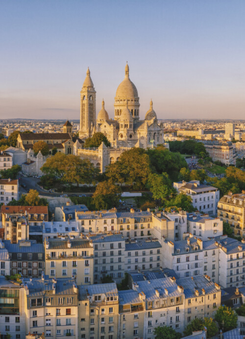 Photo de la Basilique sur la butte Montmartre et de la ville de Paris baignés par la lumière du soleil couchant